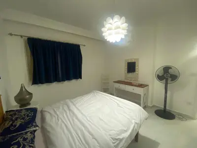 a bedroom with a bed and a lamp and a desk at One Bedroom with Balcony WI-FI Downtown Sheraton Plaza 226 in Hurghada