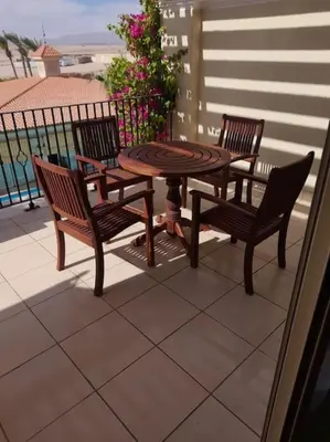 three chairs and a table on a patio at Sahl Hasheesh Deluxe penthouse Veranda in Sahl Hasheesh