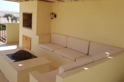 a living room with a white couch and a window at Sahl Hasheesh Deluxe penthouse Veranda in Sahl Hasheesh