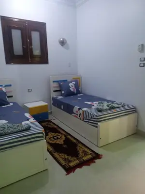 a bedroom with two twin beds and a mirror at Nubian Queen Guest House in Aswan