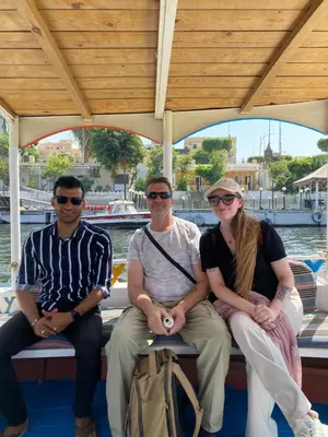 a group of three people sitting on a boat at Twilight palace in Luxor