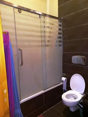 a bathroom with a toilet and a glass shower at Twilight palace in Luxor