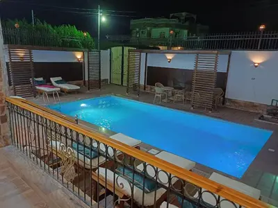 a large blue swimming pool on a balcony at night at Twilight palace in Luxor