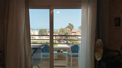 a room with a window with a view of a balcony at touristic centre in Hurghada