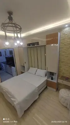 a bedroom with a large white bed and a chandelier at touristic centre in Hurghada