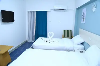 a hotel room with two beds and a tv at Lamera Hotel in Hurghada