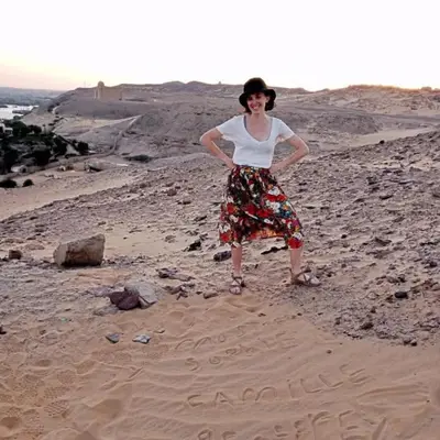 a woman standing in the sand on a beach at Zekry nubian guest house in Aswan