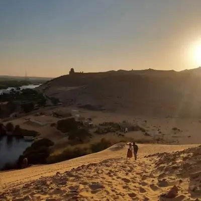 two people standing on top of a sand hill at Zekry nubian guest house in Aswan