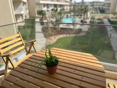 a wooden table with a potted plant on a balcony at Cozy studio in G cribs in Hurghada