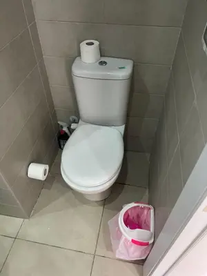 a bathroom with a toilet and a trash can at Cozy studio in G cribs in Hurghada