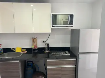 a small kitchen with a sink and a microwave at Cozy studio in G cribs in Hurghada