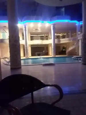 a large building with a swimming pool at night at كذا بلانكا بيتش 220 in Hurghada