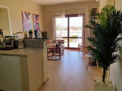 a living room with a table and a potted plant at Brand New Waterfront Sabina Ground Floor Home in Hurghada