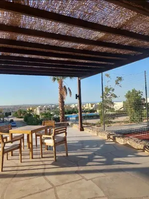 a patio with benches and a table and a palm tree at Makadi heights luxury complex in Hurghada