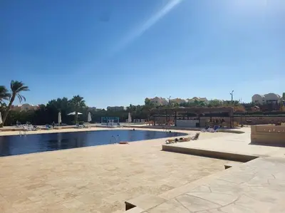 a large swimming pool with people sitting around it at Makadi heights luxury complex in Hurghada