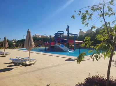 a pool with a slide and a playground with umbrellas at Makadi heights luxury complex in Hurghada
