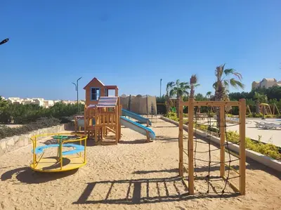 a playground with a slide and a swing set at Makadi heights luxury complex in Hurghada