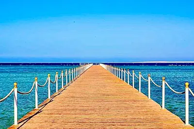 a wooden pier stretches out into the ocean at شقة داخل كمباوند in Hurghada