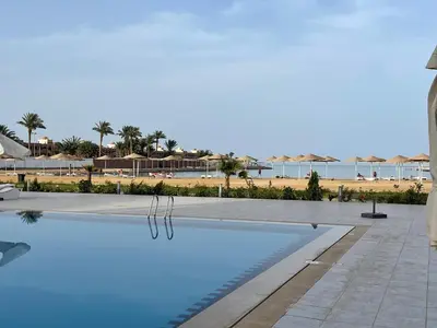 a swimming pool with a beach in the background at شقة داخل كمباوند in Hurghada