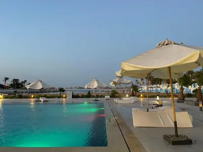 a swimming pool with umbrellas and chairs and a pool at شقة داخل كمباوند in Hurghada