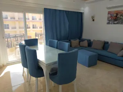 a living room with a table and a blue couch at Red Sea Panorama in Hurghada