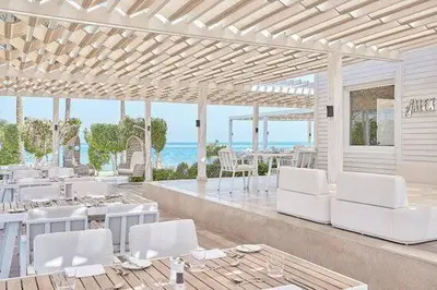 a room with white chairs and tables and the ocean at Red Sea Panorama in Hurghada