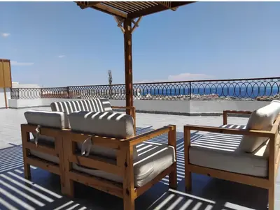 two chairs and an umbrella on a roof at Askyhomes in Hurghada