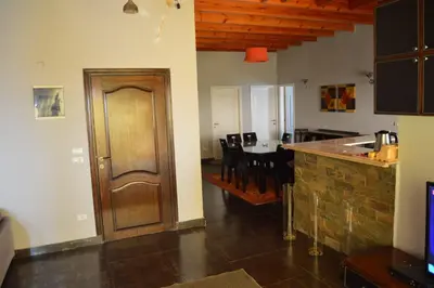 a kitchen with a wooden door and a dining room at Askyhomes in Hurghada