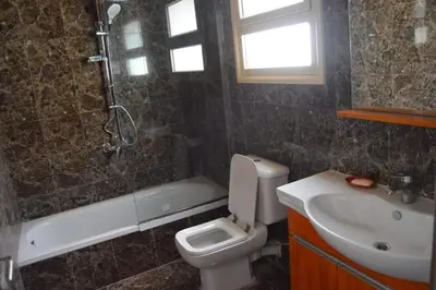 a bathroom with a sink and a toilet and a bath tub at Askyhomes in Hurghada