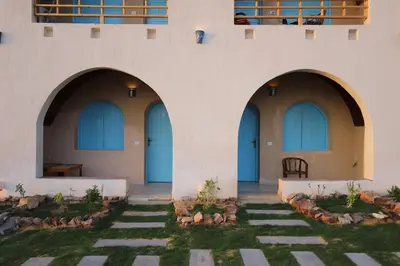 two arched entrances to a building with grass at Noprea Boutique Hotel in Aswan
