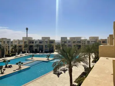 a view of a swimming pool with palm trees and buildings at Babel Apartments el gouna in Hurghada