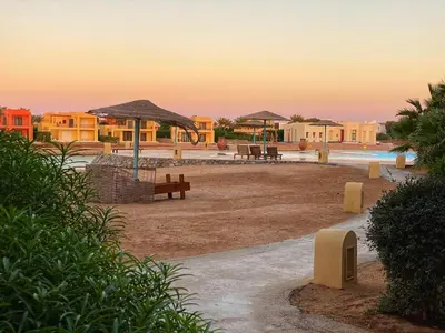 a park with benches and umbrellas on a beach at Babel Apartments el gouna in Hurghada