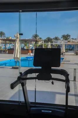 a computer monitor on a treadmill in front of a pool at Scandic resort in Hurghada