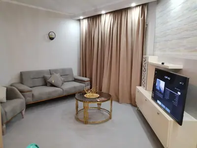 a living room with a couch and a table and a tv at Scandic resort in Hurghada