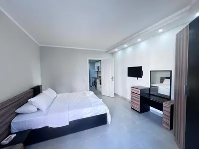 a white bedroom with a bed and a desk at Scandic resort in Hurghada