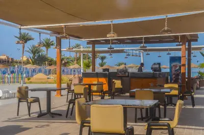 a restaurant with tables and chairs and a bar at Scandic resort in Hurghada