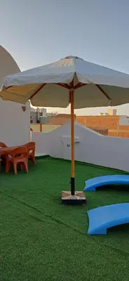 a large umbrella on top of a field of grass at Sunny sky in Quseir