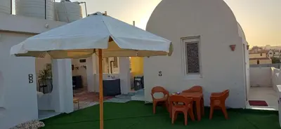 a patio with a table and chairs and an umbrella at Sunny sky in Quseir