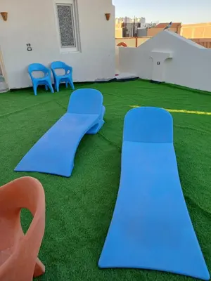 a playground with blue slides and green grass at Sunny sky in Quseir