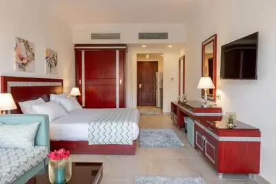 a hotel room with a bed and a couch at Oyster Bay Beach Suites in Abu Dabab