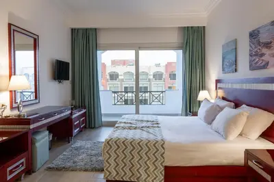 a bedroom with a bed and a large window at Oyster Bay Beach Suites in Abu Dabab