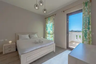 a white bedroom with a bed and a large window at Bright 2-Bedroom Apartment with Golf Course & Pool View l Cyan, El Gouna in Hurghada