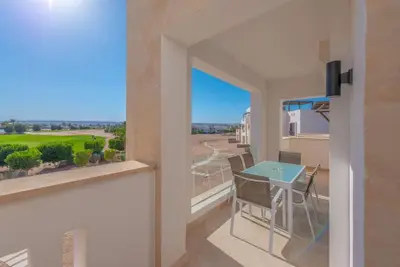 a view from the balcony of a apartment with a table and chairs at Bright 2-Bedroom Apartment with Golf Course & Pool View l Cyan, El Gouna in Hurghada