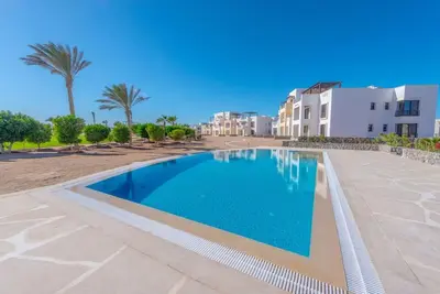 a swimming pool in front of a building at Bright 2-Bedroom Apartment with Golf Course & Pool View l Cyan, El Gouna in Hurghada