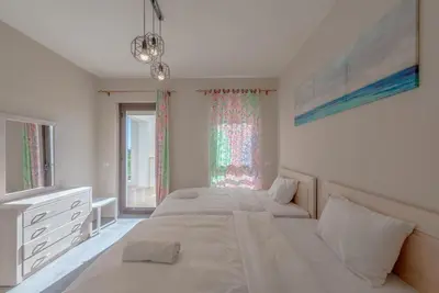 a white bedroom with two beds and a window at Bright 2-Bedroom Apartment with Golf Course & Pool View l Cyan, El Gouna in Hurghada