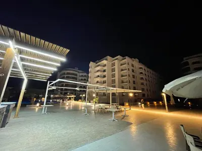 a large outdoor area with tables and buildings at night at Scandic 1 in Hurghada