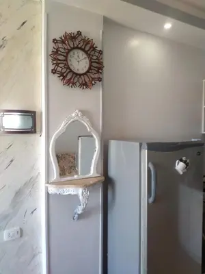 a clock on a wall next to a refrigerator at سيسيليا اتش in Hurghada