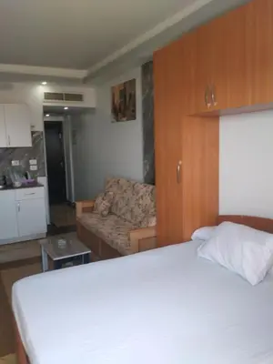 a bedroom with a white bed and a couch at سيسيليا اتش in Hurghada