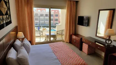 a hotel room with a bed and a large window at Oyster Bay Beach Resort - Luxury Serviced Condo in Marsa Alam City