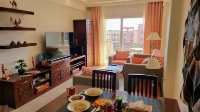a living room with a television and a table with food at Oyster Bay Beach Resort - Luxury Serviced Condo in Marsa Alam City